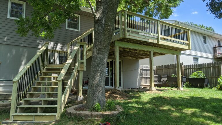Raised composite deck with metal railings and wood posts