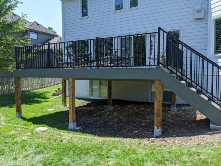 Elevated backyard deck with stairs and black metal railings