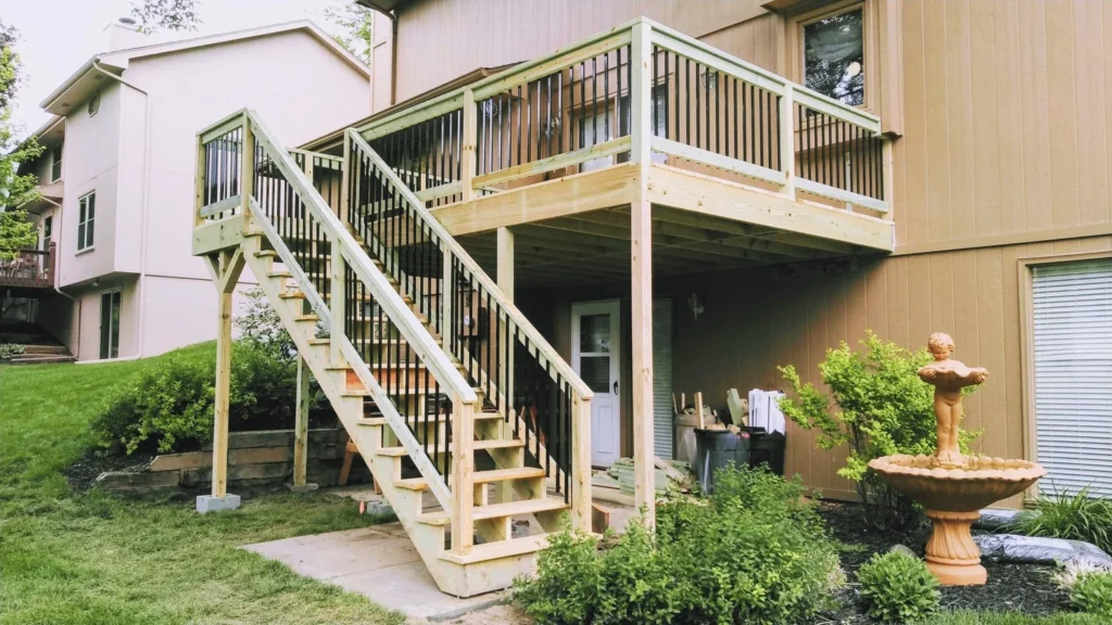 Elevated wood deck with stairs and white and black metal railings