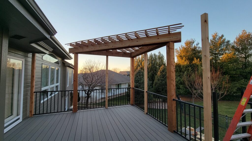 Elevated deck pergola with composite flooring and black railings