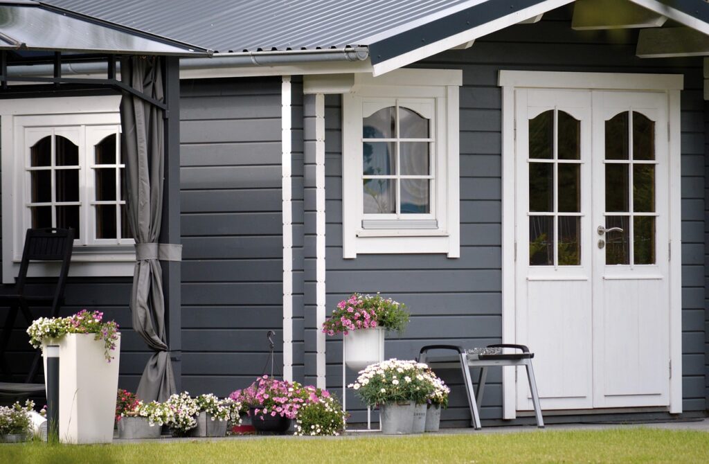 Cozy backyard shed with gray siding, white trim, and flower planters