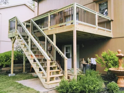 Elevated wood deck with stairs and white and black metal railings