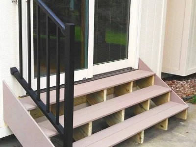 Pink composite entry steps with black metal railings and handrail