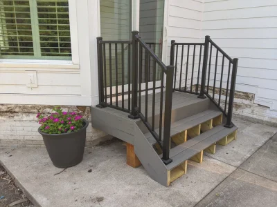 Composite platform steps with black metal railings and spindles